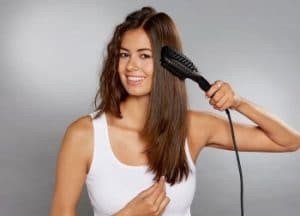 chica joven utilizando un peine alisador